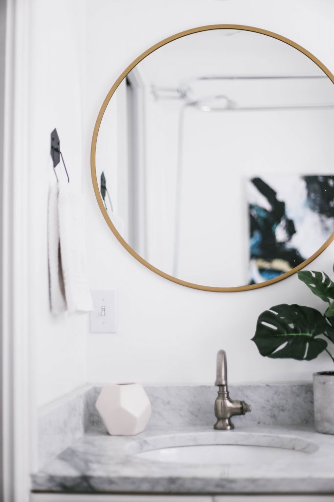 Guest Bathroom Reveal Modern Historic Downtown Charleston Home Renovation   // Charleston Fashion Blogger Dannon Almost Happening    Urban Outfitters black hexagon hand towel ring DIY cedar and moss brass sconce white clawfoot tub shower round brass vanity mirror target cement planter hex white vase white walls marble cararra countertops black and white geometric kilum rug nate burkus