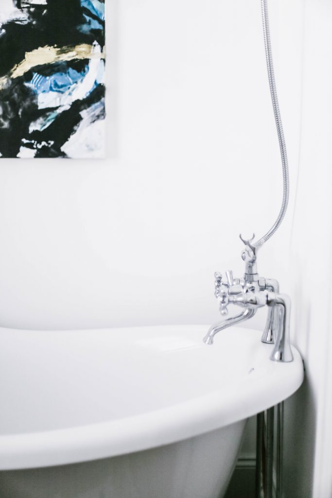 Guest Bathroom Reveal Modern Historic Downtown Charleston Home Renovation   // Charleston Fashion Blogger Dannon Almost Happening    Urban Outfitters black hexagon hand towel ring DIY cedar and moss brass sconce white clawfoot tub shower round brass vanity mirror target cement planter hex white vase white walls marble cararra countertops black and white geometric kilum rug nate burkus