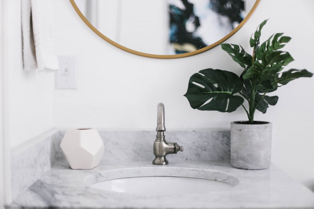 Guest Bathroom Reveal Modern Historic Downtown Charleston Home Renovation   // Charleston Fashion Blogger Dannon Almost Happening    Urban Outfitters black hexagon hand towel ring DIY cedar and moss brass sconce white clawfoot tub shower round brass vanity mirror target cement planter hex white vase white walls marble cararra countertops black and white geometric kilum rug nate burkus
